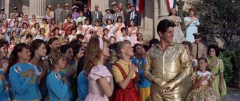 Movie still from “Bye Bye Birdie” (1963), directed by George Sidney – A group of people standing in front of a crowd of people; Medium shot, Low angle