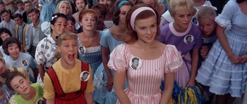 Movie still from “Bye Bye Birdie” (1963), directed by George Sidney – A group of people in a crowd wearing stickers on their faces; Medium shot, High angle