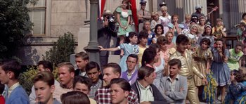 Movie still from “Bye Bye Birdie” (1963), directed by George Sidney – A large group of people gathered on the steps of a building; Medium shot, High angle