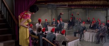 Movie still from “Bye Bye Birdie” (1963), directed by George Sidney – A group of men sitting at a table wearing red hats; Wide shot, High angle