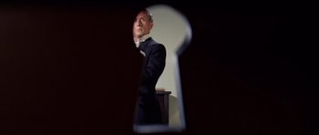 Movie still from “Bye Bye Birdie” (1963), directed by George Sidney – A man in a suit and tie standing in front of a keyhole; Extreme Close Up shot, Low angle