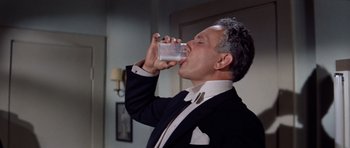 Movie still from “Bye Bye Birdie” (1963), directed by George Sidney – A man in a suit drinking from a glass; Close Up shot, High angle