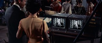 Movie still from “Bye Bye Birdie” (1963), directed by George Sidney – A woman standing in front of a television set; Medium shot, Low angle