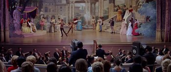 Movie still from “Bye Bye Birdie” (1963), directed by George Sidney – A crowd of people sitting in front of a painting of people dancing; Wide shot, High angle