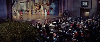 Movie still from “Bye Bye Birdie” (1963), directed by George Sidney – A group of people sitting on a stage in front of an audience; Extreme Wide shot, High angle