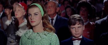 Movie still from “Bye Bye Birdie” (1963), directed by George Sidney – A girl and a boy are sitting in front of an audience; Medium shot, Low angle