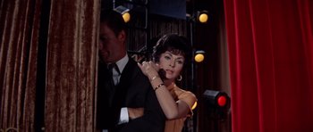 Movie still from “Bye Bye Birdie” (1963), directed by George Sidney – A man and a woman are standing in front of lights; Medium shot, Low angle