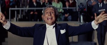 Movie still from “Bye Bye Birdie” (1963), directed by George Sidney – An older man in a tuxedo with his arms outstretched; Medium shot, Low angle