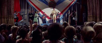 Movie still from “Bye Bye Birdie” (1963), directed by George Sidney – A group of people standing in front of an audience; Extreme Wide shot, Low angle