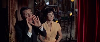 Movie still from “Bye Bye Birdie” (1963), directed by George Sidney – A man and a woman are standing next to each other in front of lights; Medium shot, Low angle