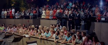 Movie still from “Bye Bye Birdie” (1963), directed by George Sidney – A group of people sitting in a room watching a show; Wide shot, High angle