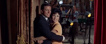 Movie still from “Bye Bye Birdie” (1963), directed by George Sidney – A man and a woman hugging in front of a camera; Medium shot, Low angle