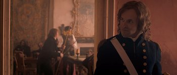 Movie still from “Byzantium” (2012), directed by Neil Jordan – A man in a uniform standing in front of a fireplace; Medium shot, Over the shoulder angle