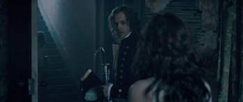 Movie still from “Byzantium” (2012), directed by Neil Jordan – A man with long hair is holding a sword; Medium shot, Over the shoulder angle