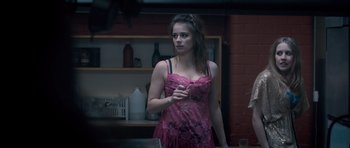 Movie still from “Byzantium” (2012), directed by Neil Jordan – A woman in a pink dress standing in front of a mirror; Medium shot, Over the shoulder angle