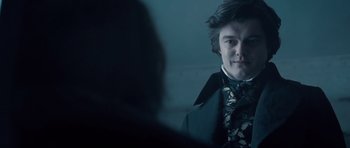 Movie still from “Byzantium” (2012), directed by Neil Jordan – A young man in a suit and tie looking at the camera; Close Up shot, Over the shoulder angle