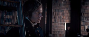 Movie still from “Byzantium” (2012), directed by Neil Jordan – A man wearing a black jacket and standing in front of a wall; Close Up shot, Over the shoulder angle