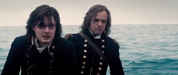 Movie still from “Byzantium” (2012), directed by Neil Jordan – Two men in military garb standing in front of the ocean; Medium shot, High angle