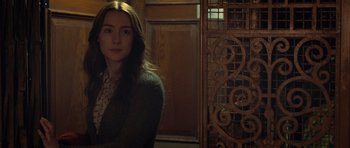 Movie still from “Byzantium” (2012), directed by Neil Jordan – A woman standing in front of an ornate iron gate; Medium shot, Over the shoulder angle