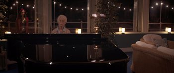 Movie still from “Byzantium” (2012), directed by Neil Jordan – An older woman sitting in front of a black piano; Medium shot, Over the shoulder angle