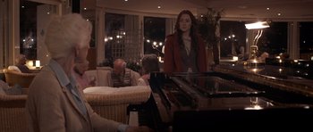 Movie still from “Byzantium” (2012), directed by Neil Jordan – A woman standing in front of a grand piano in a living room; Medium shot, Over the shoulder angle