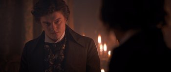 Movie still from “Byzantium” (2012), directed by Neil Jordan – A man in a suit and tie standing in front of candles; Close Up shot, Over the shoulder angle