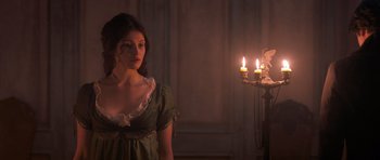 Movie still from “Byzantium” (2012), directed by Neil Jordan – A woman standing in front of a lit candle holder; Medium shot, Over the shoulder angle