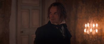 Movie still from “Byzantium” (2012), directed by Neil Jordan – A man with long black hair wearing a black coat; Close Up shot, Over the shoulder angle