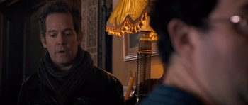 Movie still from “Byzantium” (2012), directed by Neil Jordan – Two people sitting at a table with a lamp in the middle of the room; Close Up shot, Over the shoulder angle