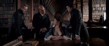 Movie still from “Byzantium” (2012), directed by Neil Jordan – Three people in a room with a book shelf in the background; Medium shot, Over the shoulder angle