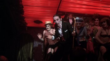 Movie still from “Cabaret” (1972), directed by Bob Fosse – A group of men and women in costume on a stage; Medium shot, Low angle
