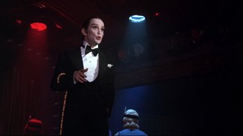 Movie still from “Cabaret” (1972), directed by Bob Fosse – A man wearing a tuxedo and a bow tie; Medium shot, Low angle