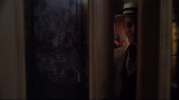 Movie still from “Cabaret” (1972), directed by Bob Fosse – A man wearing a hat standing in a room; Medium shot, Low angle