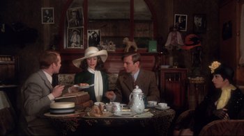 Movie still from “Cabaret” (1972), directed by Bob Fosse – A group of people sitting at a table with food; Medium shot, High angle
