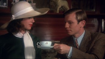 Movie still from “Cabaret” (1972), directed by Bob Fosse – A man and a woman are holding a cup of tea; Medium shot, High angle