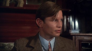Movie still from “Cabaret” (1972), directed by Bob Fosse – A man in a suit and striped tie looking to his left; Close Up shot, High angle
