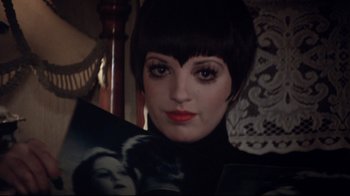 Movie still from “Cabaret” (1972), directed by Bob Fosse – A person with short black hair; Close Up shot, Over the shoulder angle