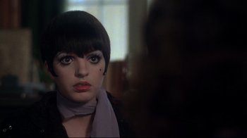 Movie still from “Cabaret” (1972), directed by Bob Fosse – A person with short black hair; Close Up shot, Over the shoulder angle