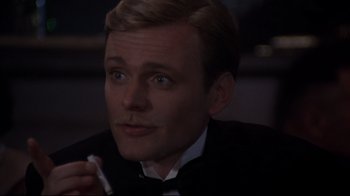 Movie still from “Cabaret” (1972), directed by Bob Fosse – A person wearing a suit and tie; Close Up shot, High angle