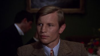 Movie still from “Cabaret” (1972), directed by Bob Fosse – A man in a brown suit and striped tie; Close Up shot, High angle