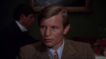 Movie still from “Cabaret” (1972), directed by Bob Fosse – A man in a brown suit and striped tie; Close Up shot, High angle