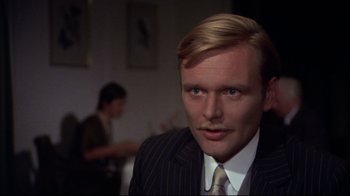 Movie still from “Cabaret” (1972), directed by Bob Fosse – A man wearing a suit and tie in front of a woman; Close Up shot, Over the shoulder angle
