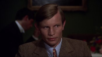 Movie still from “Cabaret” (1972), directed by Bob Fosse – A man in a suit and tie in front of a mirror; Close Up shot, High angle