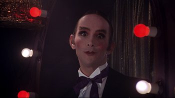 Movie still from “Cabaret” (1972), directed by Bob Fosse – A person wearing a suit and bow tie; Close Up shot, Low angle