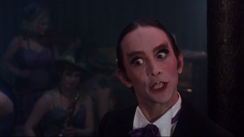 Movie still from “Cabaret” (1972), directed by Bob Fosse – A person wearing a suit and tie; Close Up shot, Low angle