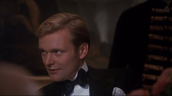 Movie still from “Cabaret” (1972), directed by Bob Fosse – A person wearing a suit and bow tie; Close Up shot, Over the shoulder angle