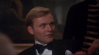 Movie still from “Cabaret” (1972), directed by Bob Fosse – A person wearing a suit and a bow tie; Close Up shot, Over the shoulder angle