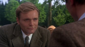 Movie still from “Cabaret” (1972), directed by Bob Fosse – A person wearing a suit and tie; Close Up shot, Over the shoulder angle