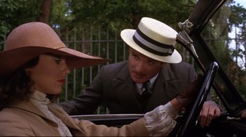 Movie still from “Cabaret” (1972), directed by Bob Fosse – A man and a woman wearing hats in a car; Close Up shot, Low angle
