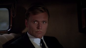 Movie still from “Cabaret” (1972), directed by Bob Fosse – A person wearing a suit and tie; Close Up shot, High angle